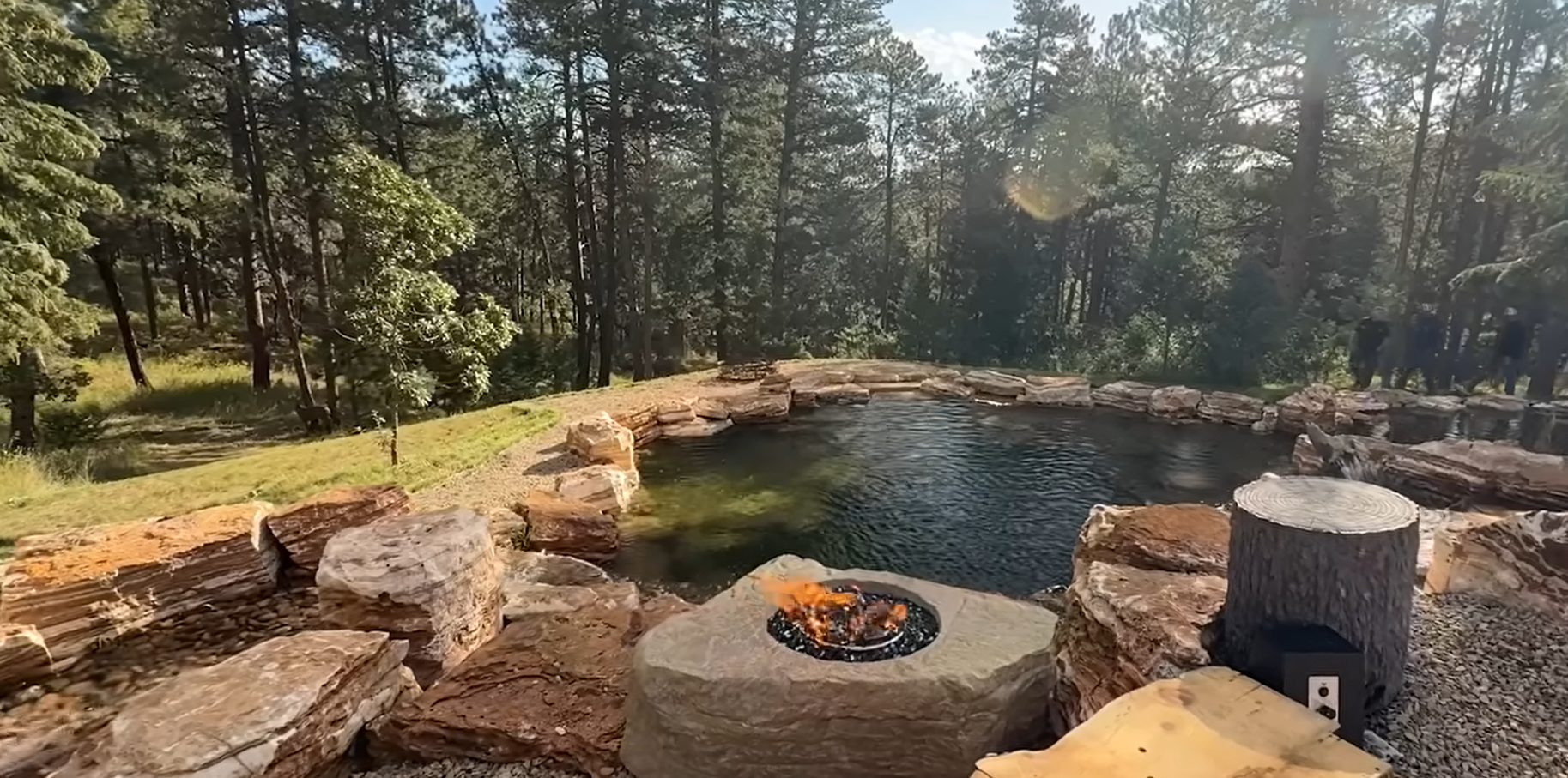 Espelho de água com bordas de pedra junto a um bosque