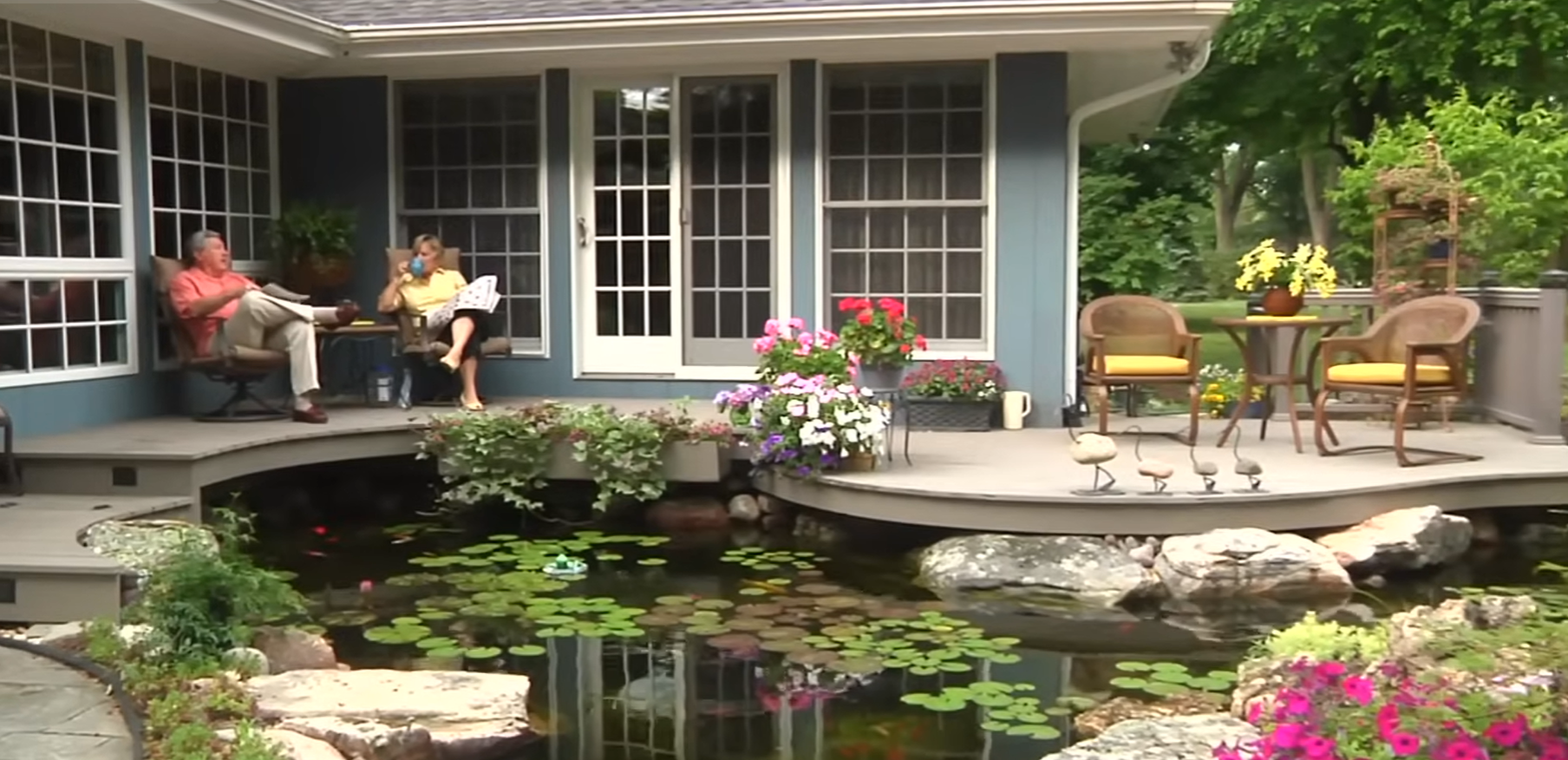 Lago com plantas aquáticas integrado à varanda de uma residência